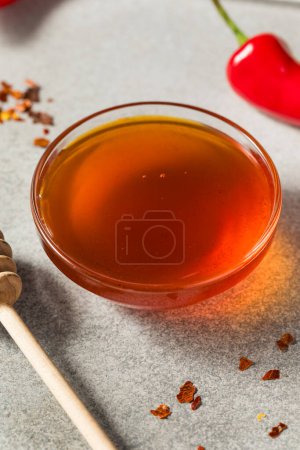 Foto de Miel caliente picante cruda orgánica en un tazón con la cacerola - Imagen libre de derechos
