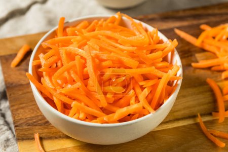 Téléchargez les photos : Morceaux de carottes râpées crues biologiques dans un bol - en image libre de droit