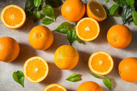 Photo for Raw Organic Juicy Oranges in a Bunch with Leaves - Royalty Free Image