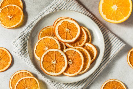 Téléchargez les photos : Tranches d'orange déshydratées séchées biologiques saines dans un bol - en image libre de droit