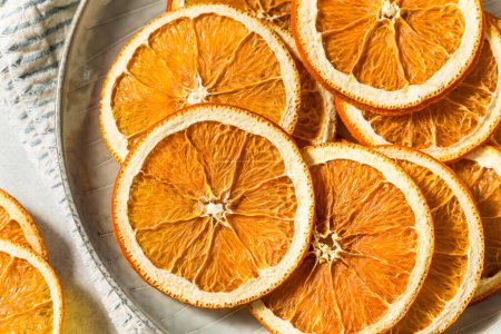 Téléchargez les photos : Tranches d'orange déshydratées séchées biologiques saines dans un bol - en image libre de droit