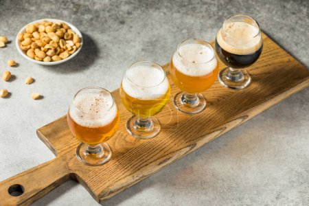 Photo for Boozy Cold Refreshing Craft Beer Flight with Peanuts - Royalty Free Image