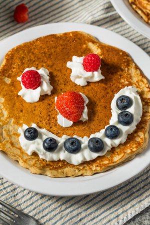 Photo for Sweet American Smiley Face Breakfast Pancakes with Whipped Cream and Berries - Royalty Free Image