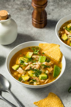 Téléchargez les photos : Soupe mexicaine de pozole de poulet faite maison avec des copeaux de tortilla - en image libre de droit