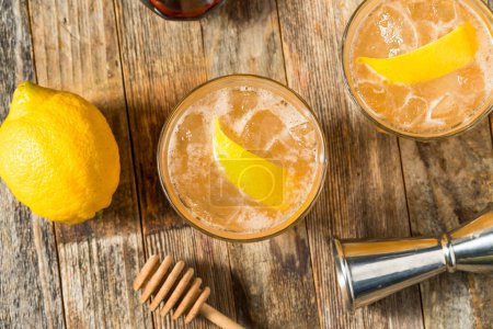 Erfrischender kalter Tequila-Honigbienen-Cocktail mit Zitrone