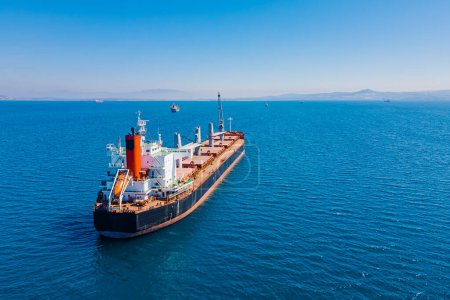 Bulk cargo carrier sea ship anchored in Aegean sea waiting entering port, Aerial view
