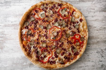 délicieuse délicieuse pizza jambon aux champignons. fond de table en bois clair. vue de dessus