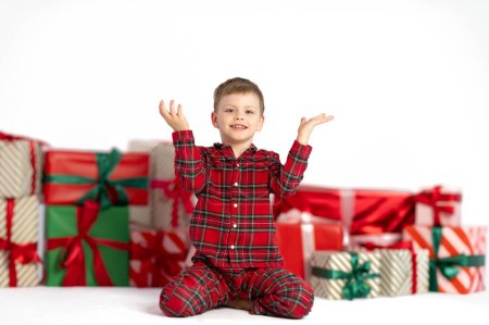 Foto de Lindo chico con regalos de Navidad para banner o fondo. Niño en pijama de franela. Felices fiestas. Foto de alta calidad - Imagen libre de derechos