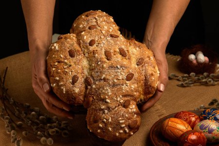 COLOMBA cake is a traditional Italian Easter dessert. Easter cake dove in women's hands close-up