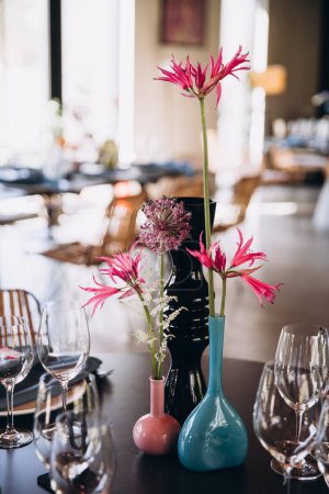 Foto de La composición de las flores de pie sobre la mesa servida en el área de la fiesta de bodas - Imagen libre de derechos