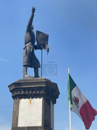 Estatua de libertador mexicano, benito Juárez, y la bandera mexicana