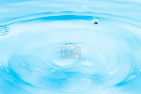 Photo for Droplets of water fall on the surface of the water and make a crown of water. - Royalty Free Image