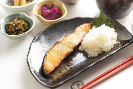 Photo for Japanese breakfast consists of healthy grilled fish and lots of side dishes - Royalty Free Image