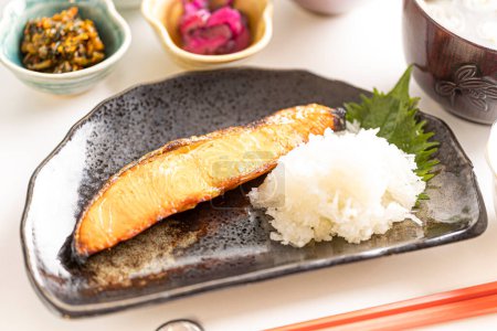 Photo for Japanese breakfast consists of healthy grilled fish and lots of side dishes - Royalty Free Image