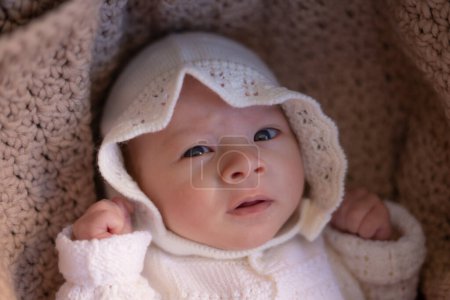Téléchargez les photos : Beau portrait de l'appartenance ethnique mixte adorable Asiatique Caucasien bébé fille de quelques semaines couché sur le chariot de bébé portant un chapeau doux dans une nouvelle vie et concept nouveau-né - en image libre de droit