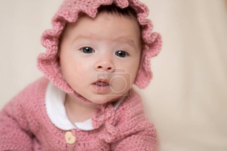 Photo for Beautiful portrait of adorable mixed ethnicity Asian Caucasian baby girl a few weeks old lying on white blanket wearing a sweet pink hat in new life and newborn concept - Royalty Free Image