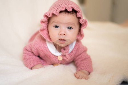 Photo for Beautiful portrait of adorable mixed ethnicity Asian Caucasian baby girl a few weeks old lying on white blanket wearing a sweet pink hat in new life and newborn concept - Royalty Free Image