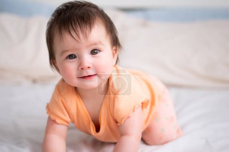 Foto de Estilo de vida casa retrato de feliz y hermosa niña de 8 meses de edad raza mixta asiático caucásico jugando alegre en la cama explorar los alrededores curioso - Imagen libre de derechos