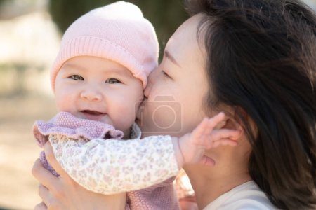 Téléchargez les photos : Pure joie comme une jeune mère chinoise asiatique joue avec amour avec sa petite fille, créant un lien durable de bonheur affectif beauté de la maternité et innocence de l'enfance - en image libre de droit
