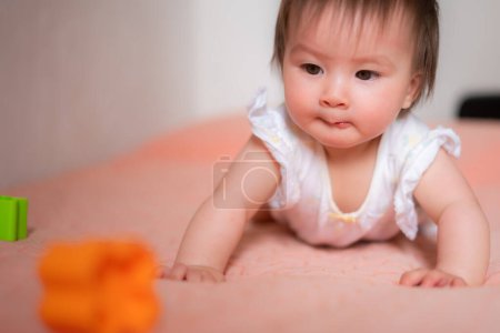 Photo for Lifestyle home portrait of adorable and beautiful Asian Caucasian mixed baby girl playing on bed with color blocks excited and happy in childhood concept - Royalty Free Image