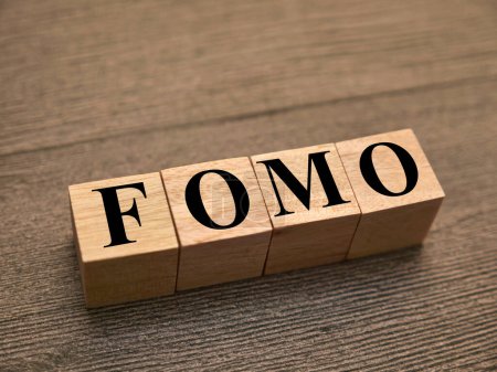 FOMO fear of missing out, text words typography written with wooden letter, life and business motivational inspirational concept