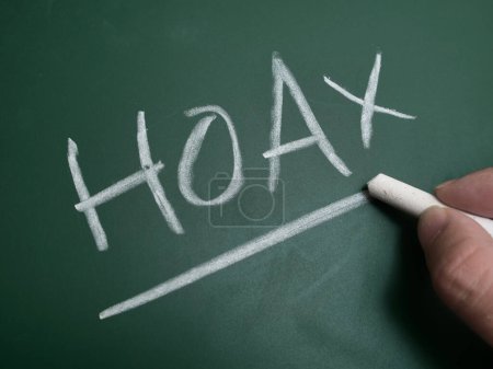 Hoax, text written on chalkboard, fake news gossip issue concept