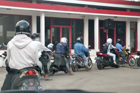 Foto de Tenggarong, Indonesia, diciembre 2023, Scooters cola de bicicleta esperando la gasolina pertalita en la gasolinera Pertamina - Imagen libre de derechos