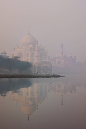 View of Taj Mahal at sunrise reflected in Yamuna river with fog, Agra, Uttar Pradesh, India. Taj Mahal was designated as a UNESCO World Heritage Site in 1983.
