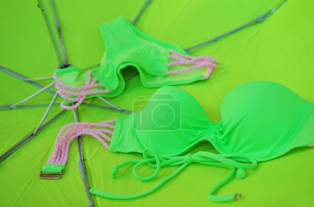 Téléchargez les photos : Fond d'été abstrait lumineux avec maillot de bain vert néon sur parapluie jaune - en image libre de droit