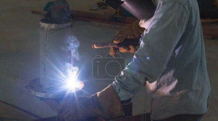 Photo for Welder performs welding work semi-automatic electric arc welding. MIG welding. - Royalty Free Image
