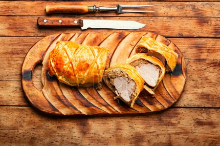 Photo for Meat dish is wellington meat, meat baked in dough. Meat loafs on old wooden table - Royalty Free Image
