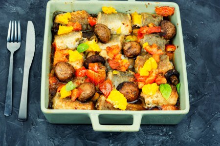 Téléchargez les photos : Merlu cuit au four avec orange, tomate et champignons. Fruits de mer rôtis au four - en image libre de droit