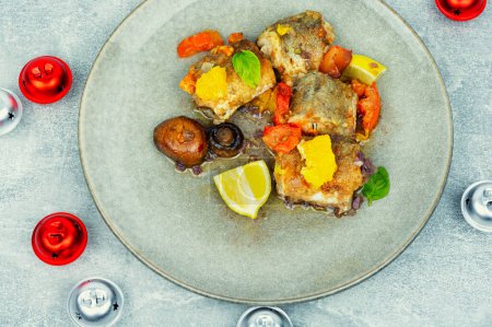 Téléchargez les photos : Merlu de poisson cuit aux champignons, à l'orange et aux tomates. Alimentation de Noël - en image libre de droit