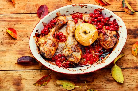Téléchargez les photos : Jambes de poulet cuites dans un plat allant au four avec des pommes et des baies. Recette de viande d'automne. - en image libre de droit