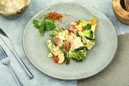 Téléchargez les photos : Asperges enveloppées dans du bacon, cuites avec des tomates, brocoli et fromage. Casserole maison - en image libre de droit