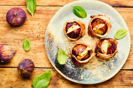 Photo for Ripe figs wrapped in bacon. Festive snack on rustic wooden table.Top view - Royalty Free Image