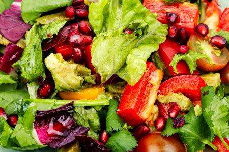 Téléchargez les photos : Salade vitaminée avec légumes verts, poivre et concombre, décorée de grenade. Contexte alimentaire - en image libre de droit