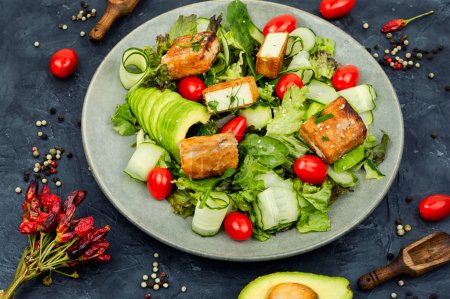 Photo for Tasty salad of greens, cucumber, avocado, tomatoes and grilled tofu soy cheese. Healthy Vegetarian Meals - Royalty Free Image