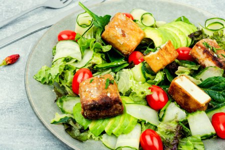 Photo for Fresh summer salad with green, cucumber, avocado, tomatoes,sesame seeds and tofu cheese. Healthy vegetarian meals - Royalty Free Image