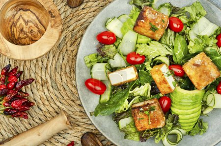 Téléchargez les photos : Délicieuse salade avec laitue, concombre, avocat et fromage de soja tofu rôti. Cuisine végétarienne - en image libre de droit