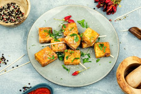 Photo for Grilled tofu cheese skewers and sesame seeds on the plate.Homemade healthy vegetarian dishes - Royalty Free Image