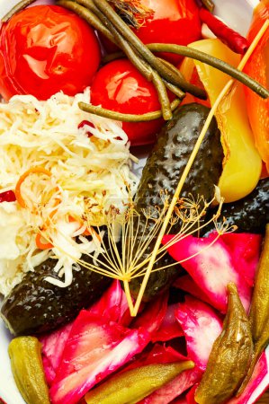Téléchargez les photos : Déposer les cornichons de légumes salés, marinés épicés sur une assiette. Aliments en conserve - en image libre de droit