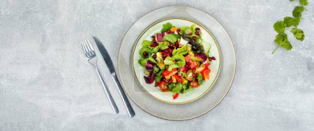 Photo for Vitamin salad with greens, pepper, red lettuce and cucumber, decorated with pomegranate. Space for text - Royalty Free Image