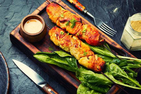 Photo for Appetizing chicken meat, chicken breast roasted on wooden skewers. Kebabs on cutting board - Royalty Free Image