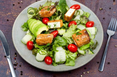 Photo for Homemade lettuce salad with cucumber, avocado and fried tofu soy cheese. Healthy lifestyle - Royalty Free Image