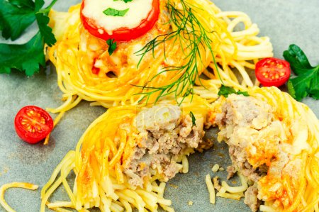 Téléchargez les photos : Nid savoureux de spaghettis farcies boulettes de viande et de tomate - en image libre de droit