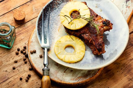 Foto de Grilled beef meat with pineapple. Steak with pineapple sauce on plate - Imagen libre de derechos