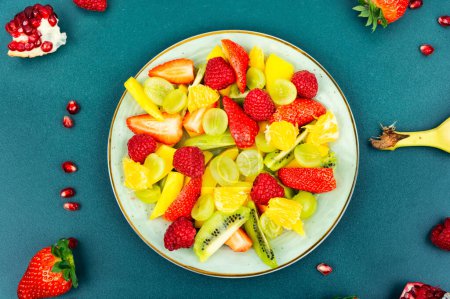 Foto de Vitamin salad of mango, citrus, banana and berries in a bowl - Imagen libre de derechos