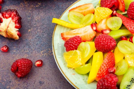 Photo for Vitamin vegetarian salad of mango, citrus, banana and berries in a bowl - Royalty Free Image