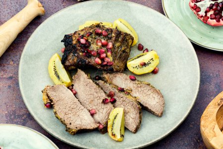 Téléchargez les photos : Cooked veal meat in kiwi and pomegranate sauce. - en image libre de droit